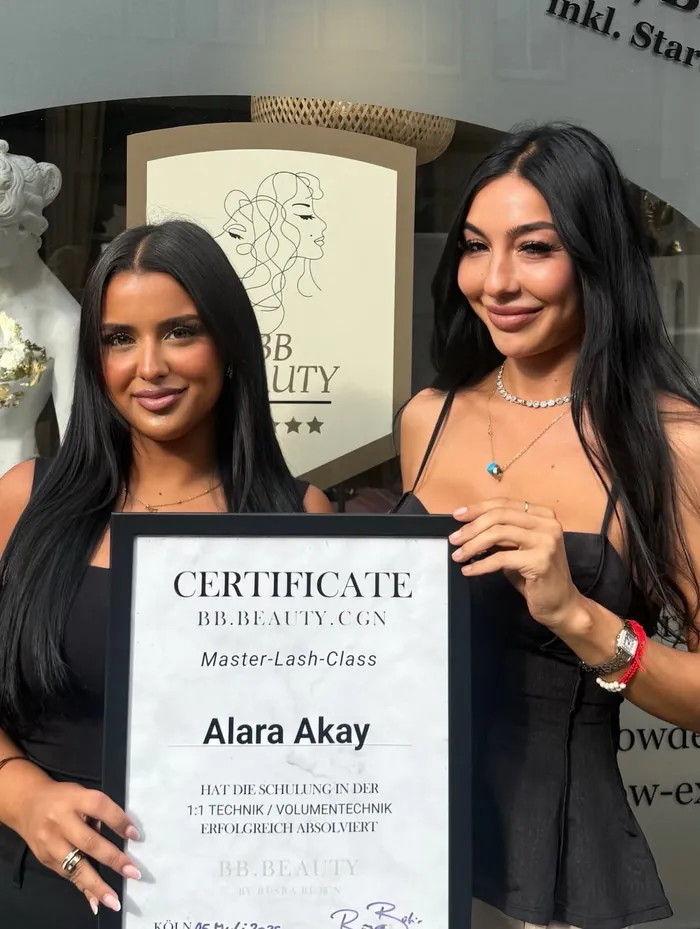 Absolventin Alara mit ihrem Zertifikat der Master Lash Class vor dem Studio